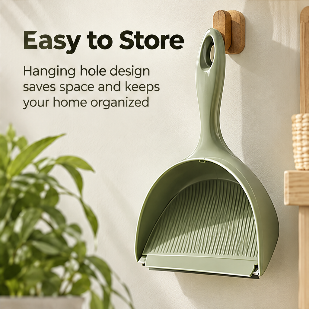 Sage green dustpan hanging from its handle opening